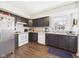 Clean kitchen features dark cabinets, white appliances, and a bright window view at 6413 N Wheeling Ave, Muncie, IN 47304