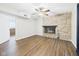 Living room showcasing a stone fireplace, hardwood floors, and a ceiling fan at 6413 N Wheeling Ave, Muncie, IN 47304