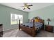 Bright bedroom with a ceiling fan, side table, and large window at 6524 Turf Way, Anderson, IN 46013