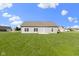 Exterior shot of the house back, revealing a simple design, a well-manicured lawn, and several evenly spaced windows at 6524 Turf Way, Anderson, IN 46013