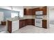 Modern kitchen with stainless steel appliances, wood cabinets, and white tile flooring at 6524 Turf Way, Anderson, IN 46013