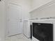 Bright laundry room featuring a washer, dryer, shelving, and a door for access to the outside at 6524 Turf Way, Anderson, IN 46013