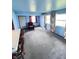 An expansive room with carpet, blue walls and an opening into the kitchen area at 6835 W Us Highway 36, Danville, IN 46122