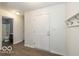 Welcoming foyer features wood-look flooring, coat hooks, and entry to the hall bathroom at 7951 Busby Bend Dr, Noblesville, IN 46062