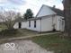 View of the house exterior, showcasing the detached garage and grassy yard with some landscaping at 909 S Colfax St, Martinsville, IN 46151
