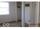 A bedroom with a closet, window, and view to another room with a paneled door at 909 S Colfax St, Martinsville, IN 46151