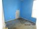 A bedroom with blue walls, an electrical outlet, and window at 909 S Colfax St, Martinsville, IN 46151