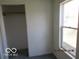 A bedroom with a closet, window, and neutral carpet at 909 S Colfax St, Martinsville, IN 46151