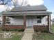Charming home featuring a covered porch with brick supports, a symmetrical design, and a well-maintained lawn at 909 S Colfax St, Martinsville, IN 46151