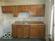 Kitchen featuring wooden cabinets, a laminate countertop, and a sink with basic fixtures at 909 S Colfax St, Martinsville, IN 46151