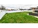 Fully fenced backyard with a green lawn, seating area, and a small storage shed offers both functionality and privacy at 1015 Main St, Elwood, IN 46036