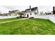 The backyard offers a large lawn enclosed by a white fence providing privacy and space for outdoor activities at 1015 Main St, Elwood, IN 46036