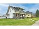 Lovely home exterior with charming front porch, green lawn, and inviting curb appeal in a suburban setting at 1015 Main St, Elwood, IN 46036