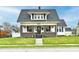 Charming two-story home features a covered front porch, well-maintained lawn, and classic architectural details at 1015 Main St, Elwood, IN 46036