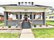 Charming front porch with decorative columns, hanging plants, and inviting entrance enhances the curb appeal at 1015 Main St, Elwood, IN 46036