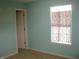 Bright bedroom with light blue walls, a window with patterned curtains, and a neutral carpet at 10762 Galant Fox Ct, Indianapolis, IN 46234