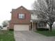 Two-story brick home with an attached two-car garage and flowering tree in front at 10762 Galant Fox Ct, Indianapolis, IN 46234