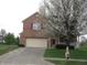 Two-story brick home with an attached two-car garage and flowering tree in front at 10762 Galant Fox Ct, Indianapolis, IN 46234