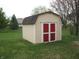 Backyard view of storage shed with red doors and beige siding at 10762 Galant Fox Ct, Indianapolis, IN 46234