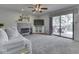 Bright living room with stone fireplace, sliding glass doors to patio, ceiling fan, and plush carpeting at 1228 Easton Point Dr, Greenwood, IN 46142