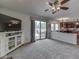 Sun-filled living room open to the kitchen, featuring sliding glass doors to the patio, neutral colors, and plush carpeting at 1228 Easton Point Dr, Greenwood, IN 46142
