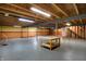 Unfinished basement with exposed ceiling, support beams, cement floor, half painted walls, and wooden shelves at 12404 Rose Haven Dr, Indianapolis, IN 46235
