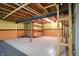 Unfinished basement with exposed ceiling, support beams, tiled floor, half painted walls, and wooden shelves at 12404 Rose Haven Dr, Indianapolis, IN 46235