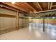 Unfinished basement with exposed ceiling, support beams, tiled floor, half painted walls, and wooden shelves at 12404 Rose Haven Dr, Indianapolis, IN 46235
