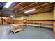 Unfinished basement with exposed ceiling, support beams, cement floor, half painted walls, and wooden shelves at 12404 Rose Haven Dr, Indianapolis, IN 46235