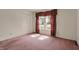 Bedroom with neutral mauve carpet, large window with burgundy drapes, and double-door closet at 12404 Rose Haven Dr, Indianapolis, IN 46235