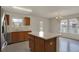 Open kitchen with island, wooden cabinets, stainless steel appliances, and backyard view at 12404 Rose Haven Dr, Indianapolis, IN 46235