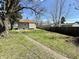 Expansive backyard featuring mature trees, green grass, and a partial view of the home at 1302 Lindley Ave, Indianapolis, IN 46241