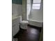 This bright bathroom offers a tiled shower-tub, wood-look flooring, and ample storage space for essentials at 1302 Lindley Ave, Indianapolis, IN 46241