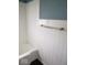This bathroom features white tile and blue accent paint, complete with a convenient grab bar in the tub area at 1302 Lindley Ave, Indianapolis, IN 46241