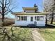 Charming, bright white one-story home with a well-manicured front yard and sidewalk to entry at 1302 Lindley Ave, Indianapolis, IN 46241