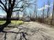 Detached garage with gravel driveway with mature trees providing shade at 1302 Lindley Ave, Indianapolis, IN 46241