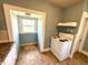 Compact kitchen with a vintage stove, window nook, and vinyl flooring at 1302 Lindley Ave, Indianapolis, IN 46241