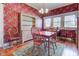 Cozy dining room with floral wallpaper, wood floors, vintage hutch, and traditional wooden table with seating at 1325 Fordice Rd, Lebanon, IN 46052