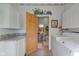 Laundry room with white cabinets and granite countertops seen through wooden doorway to the bathroom at 1325 Fordice Rd, Lebanon, IN 46052