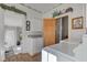 Laundry room with washer, dryer, white cabinets, view through the wooden door into another room at 1325 Fordice Rd, Lebanon, IN 46052