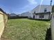 Wide angle view of a green backyard featuring a new fence, patio with pergola, and a storage shed at 1404 Alonzo Pl, Indianapolis, IN 46217