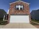 Home exterior featuring a brick front with a garage door and neatly kept lawn at 1404 Alonzo Pl, Indianapolis, IN 46217