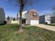 View of the home's front, showing the attached garage and lawn at 1404 Alonzo Pl, Indianapolis, IN 46217