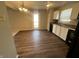 Bright kitchen with white cabinets, dark appliances, laminate countertops, wood-look floors, and an adjacent door to outside at 1404 Alonzo Pl, Indianapolis, IN 46217
