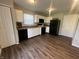 Updated kitchen with white cabinets, black appliances, and wood-look flooring at 1404 Alonzo Pl, Indianapolis, IN 46217