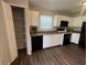 Bright kitchen with white cabinets, black appliances, laminate countertops, wood floor, and an adjacent pantry at 1404 Alonzo Pl, Indianapolis, IN 46217