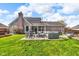 Expansive backyard with patio seating, a barbecue grill, and lush green grass, perfect for outdoor living at 1598 Thornburg Ln, Franklin, IN 46131