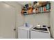 A practical laundry room with a washer and dryer, with storage shelf filled with cleaning supplies above at 16838 Aulton Dr, Noblesville, IN 46060