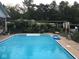 Outdoor pool with clean, clear water surrounded by well-maintained landscaping and a privacy fence at 1791 S Conservation Club Rd, Morgantown, IN 46160