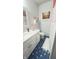 Cozy bathroom featuring blue hexagonal tile flooring, white vanity, decorative artwork, and ample natural light at 1813 Birch Dr, Plainfield, IN 46168